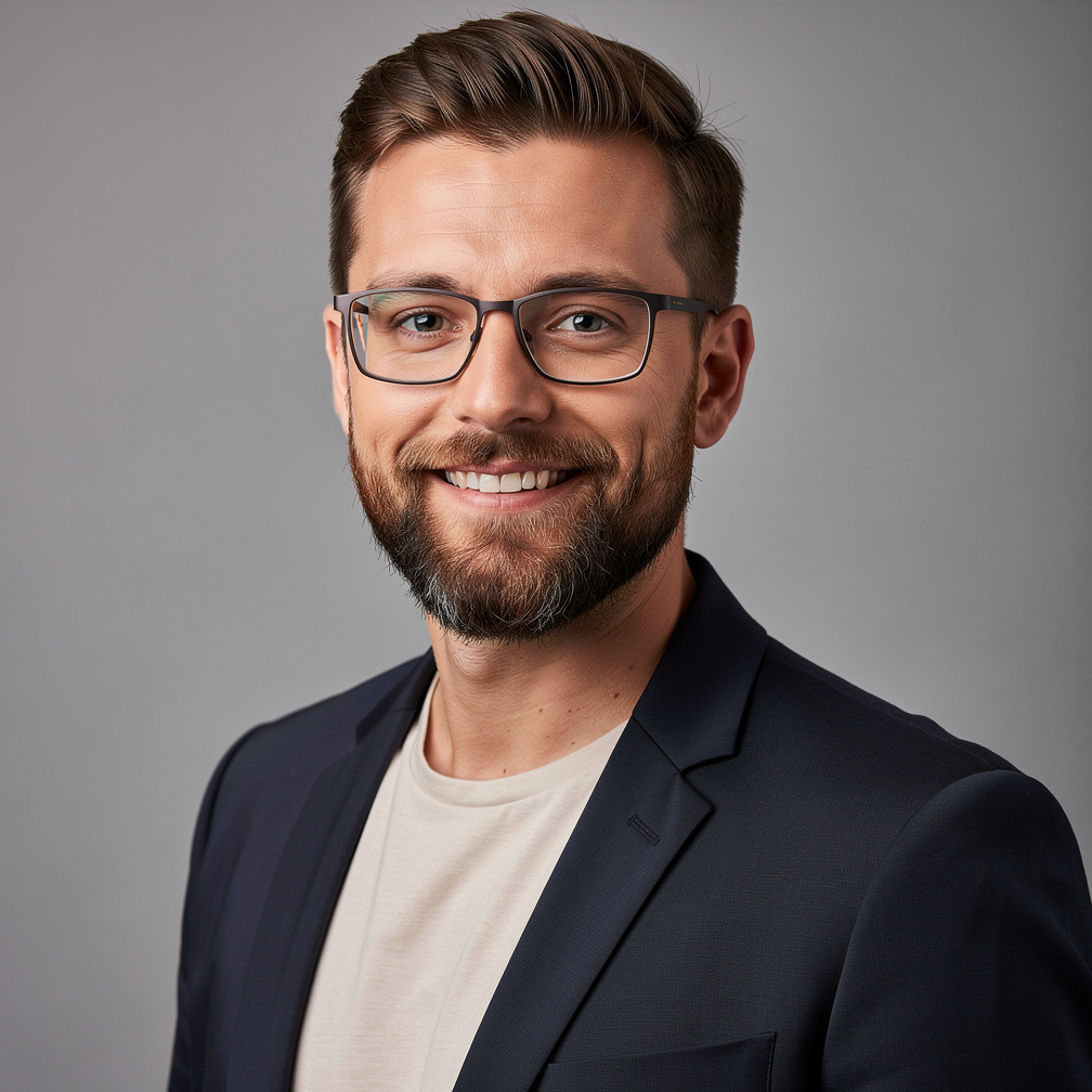 Studio photo of a bearded man in glasses